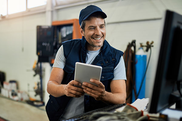 Male Mechanic looking up a manuel on a tablet